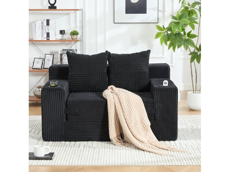  Fauteuil pouf double avec coussins, accoudoirs et poches latérales en velours côtelé noir, 151 × 133 × 64 cm  - Conforama C